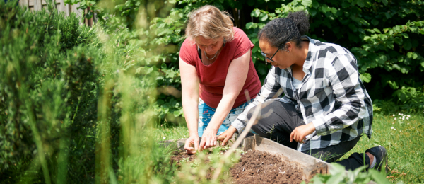 Gehandicaptenzorg Begeleider aan de slag met een cliënt in de tuin 